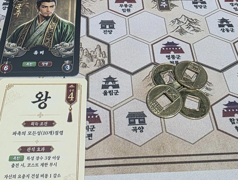 군주 카드 유비와 관직 카드 왕, 지도 위의 오수전 네 닢